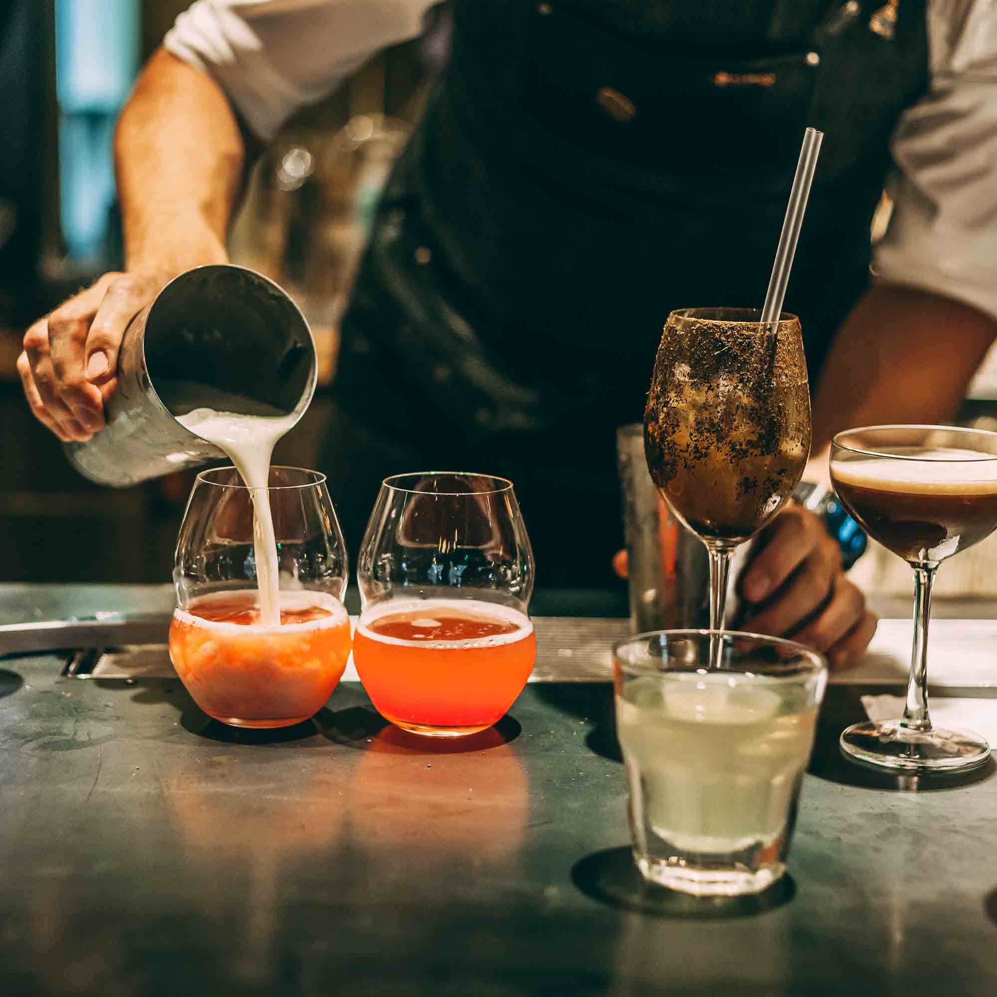 A C'est La Vie Cafe bartender preparing a handcrafted cocktail